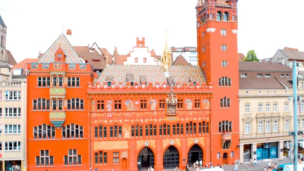 The City Hall in Basel, Switzerland is a large red building with mosaics. A must-see for what to do in Basel