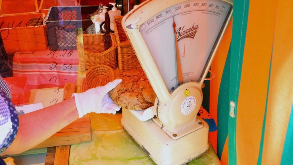 Weiden bread employee weighing a loaf of local bread