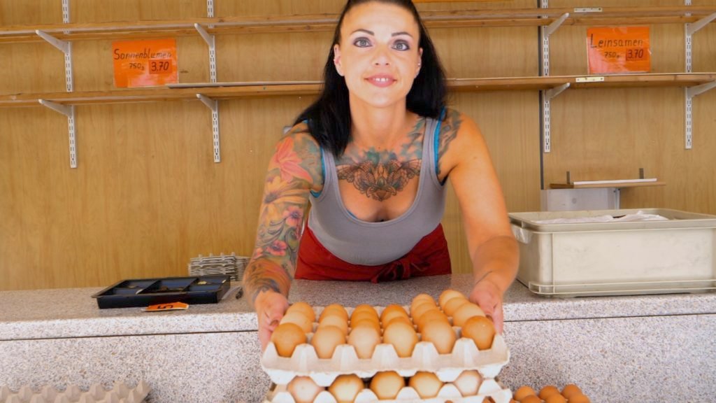 Weiden woman displaying fresh cartons of local eggs